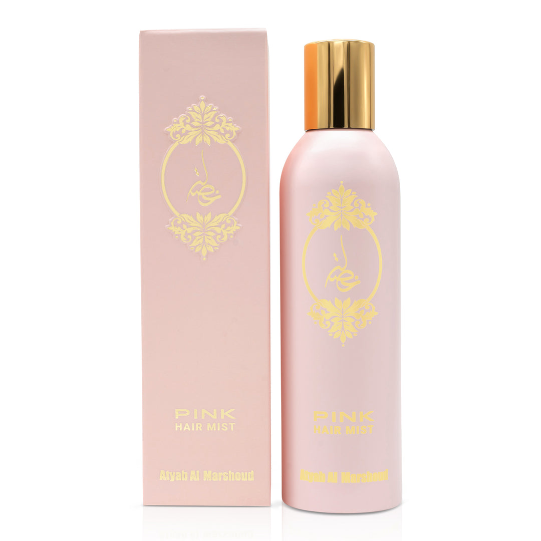 Light pink body essence bottle with a gold cap standing next to its matching pink product box featuring gold floral design.